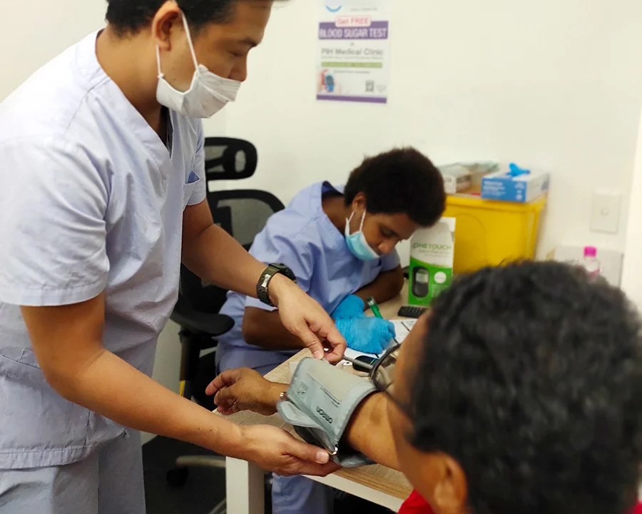 Medical professional taking blood pressure of a patient at Nambawan Super Plaza medical centre